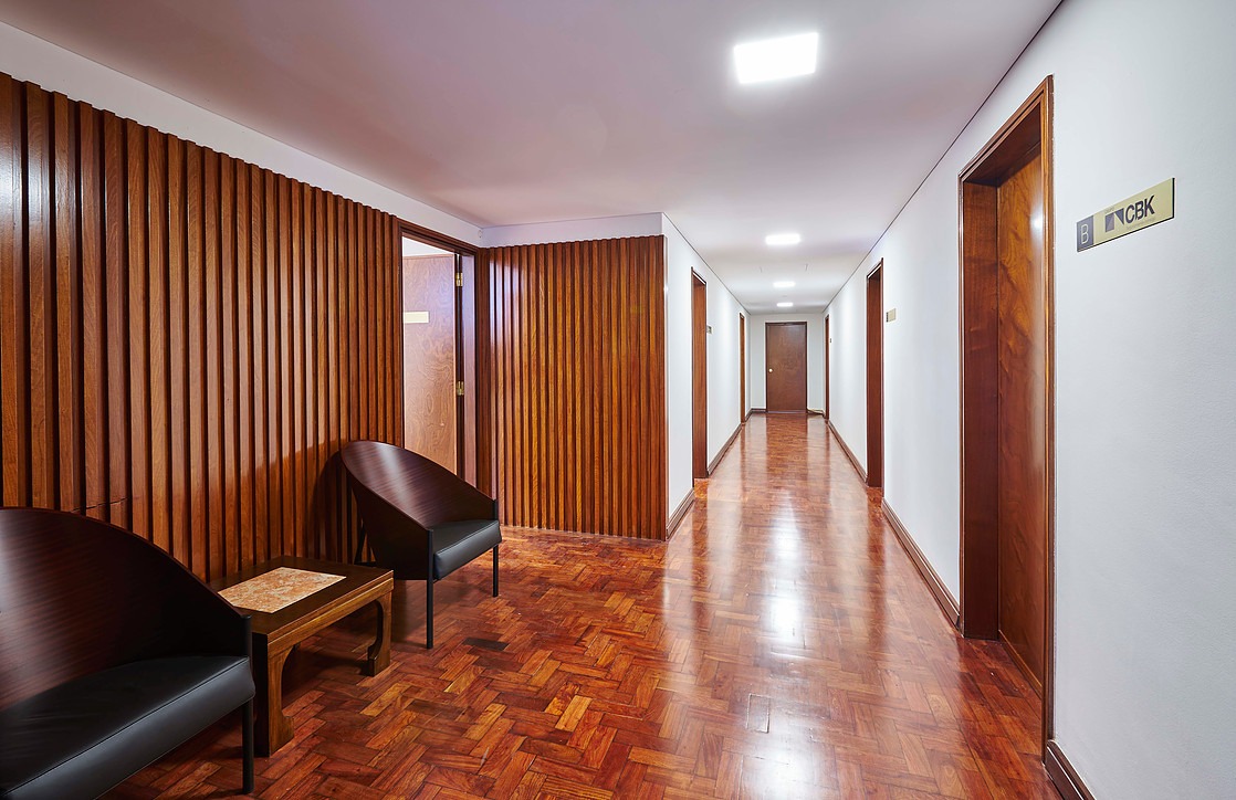 Lobby do edifício com piso em mármore e placard de empresas