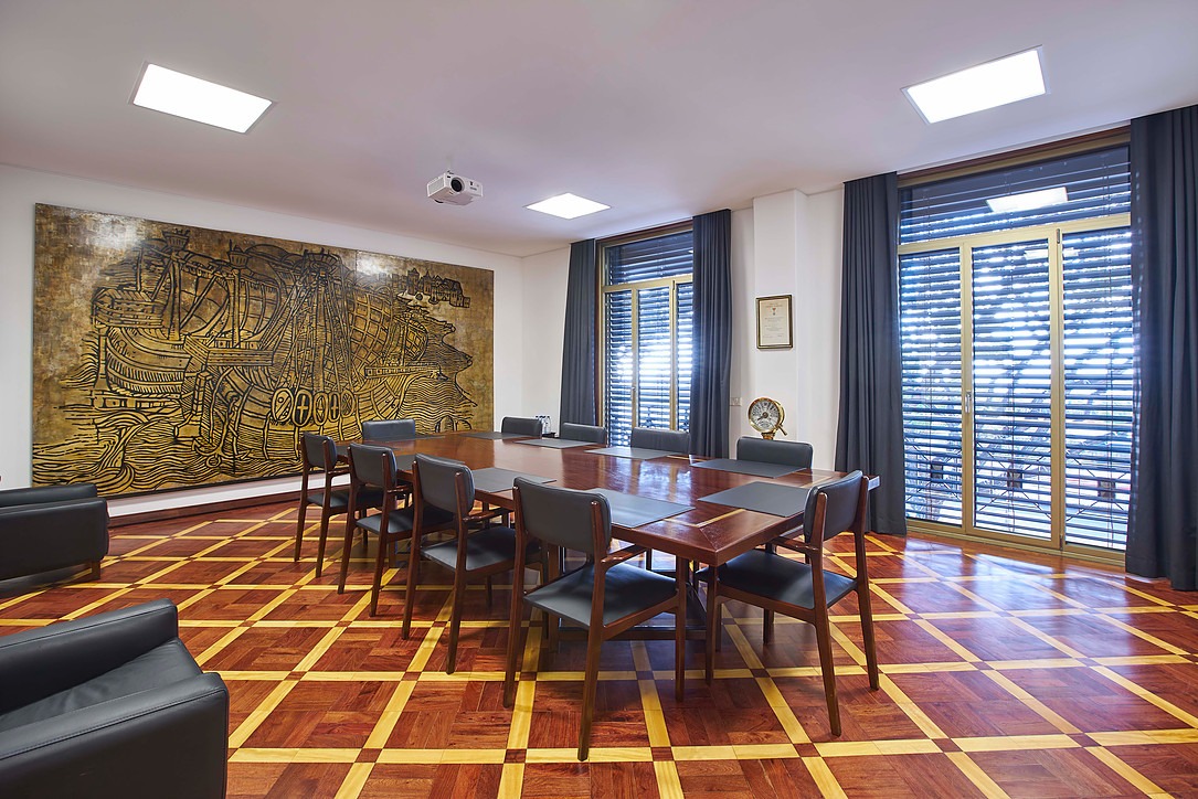 Sala de reuniões com arte mural e pavimento em madeira geométrica